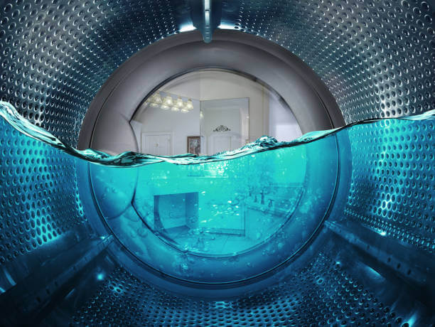 Gros plan sur le tambour d’une machine à laver partiellement immergé dans une eau bleue claire pour l'entretien des chaussettes fantaisie.
